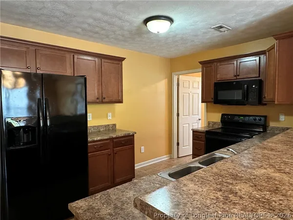 a kitchen with a refrigerator and a stove top oven