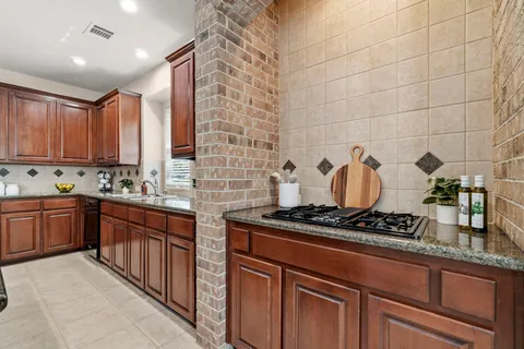 a kitchen with stainless steel appliances granite countertop a stove a sink and cabinets