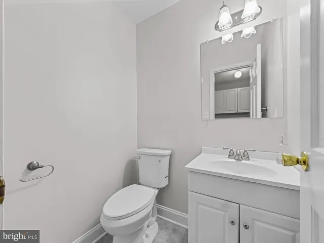 a bathroom with a toilet sink vanity and mirror