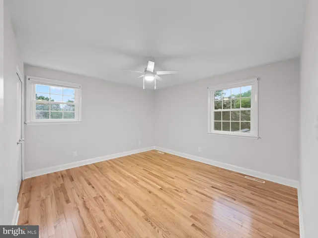 a view of a big room with wooden floor and windows