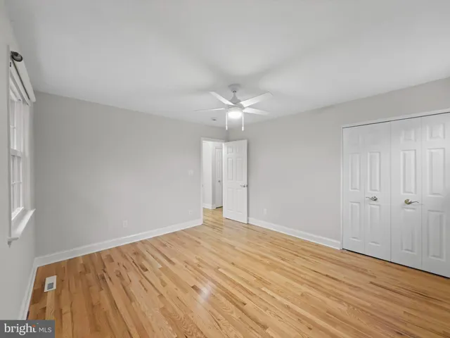 a view of an empty room with wooden floor