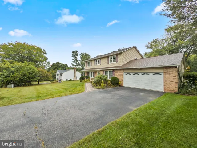 a view of a house with a big yard and large tree