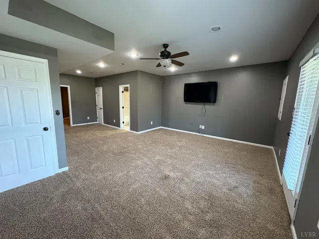 en empty room with windows and ceiling fan