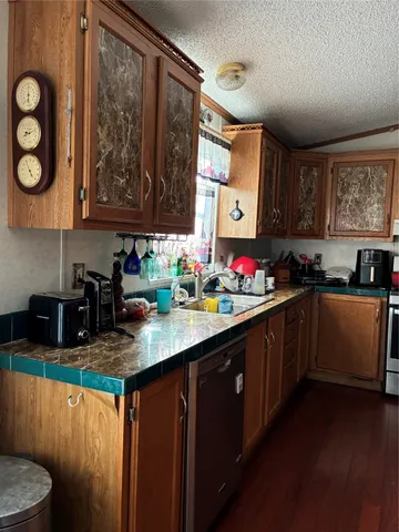 a kitchen with stainless steel appliances granite countertop a sink stove and cabinets