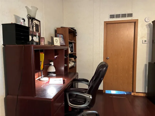 a view of a workspace with furniture and wooden floor