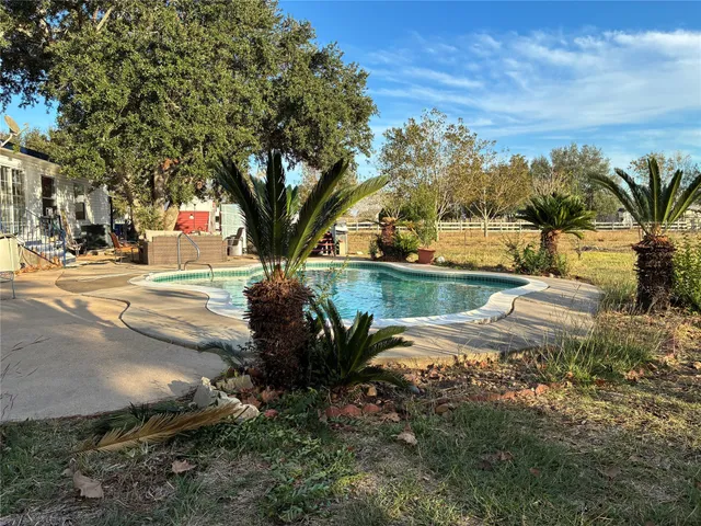 a view of a yard with plants and trees