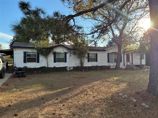 a backyard of a house with barbeque oven fire pit table and chairs