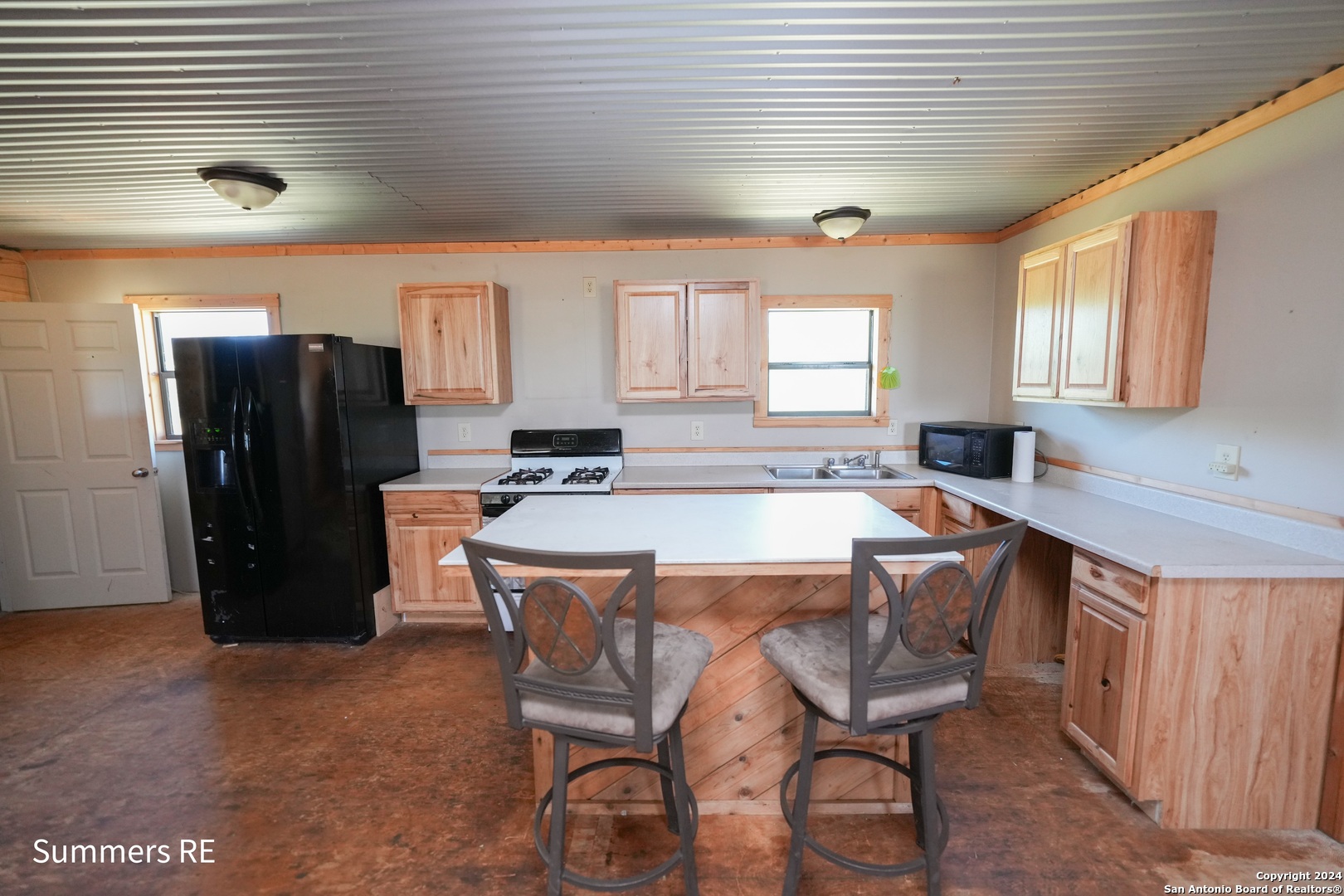 5077 Old Pontotoc Road Mason, TX 76856 - Photo 29 of 41 a kitchen with a table chairs refrigerator and window