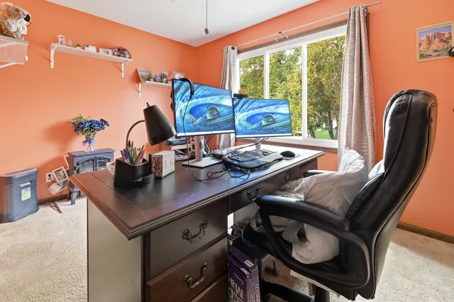 a view of a workspace with furniture and window