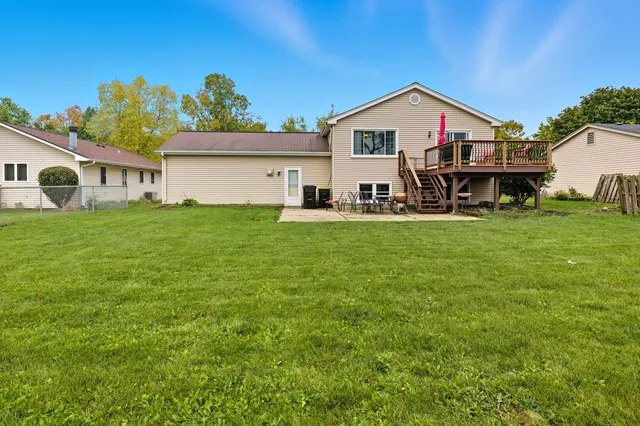 a view of a house with a big yard and large trees