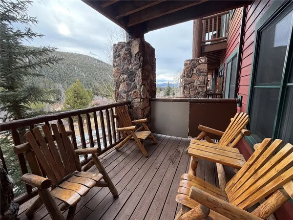 a balcony with wooden floor and outdoor seating