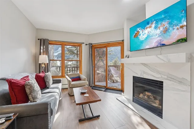 a living room with furniture a fireplace and a large window