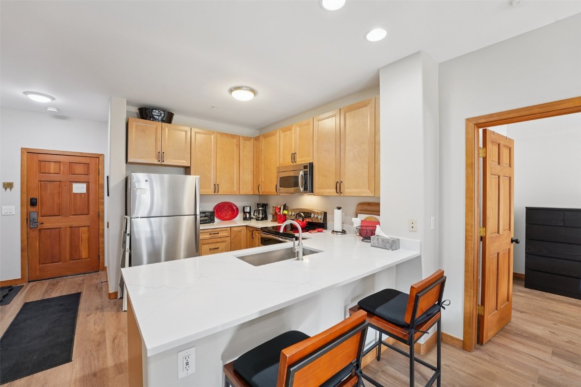22714 Highway 6, Unit 5971 Keystone, CO 80435 - Photo 6 of 21 a kitchen with a sink a refrigerator and wooden floor