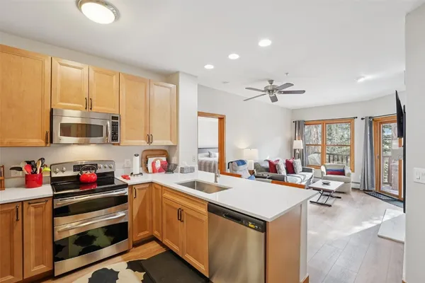 a view of a kitchen with kitchen island a sink appliances and a counter top space