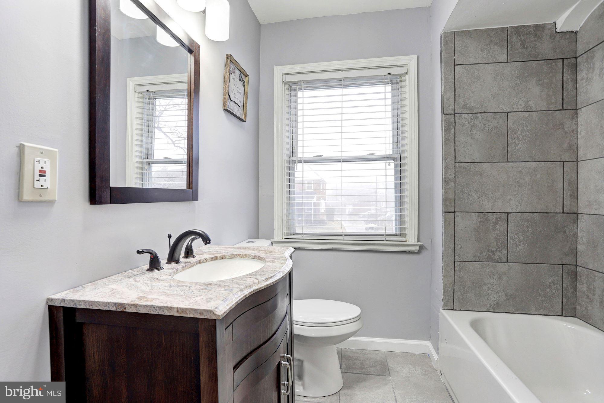4510 Marble Hall Road Baltimore, MD 21239 - Photo 16 of 24 a bathroom with a granite countertop sink toilet and mirror