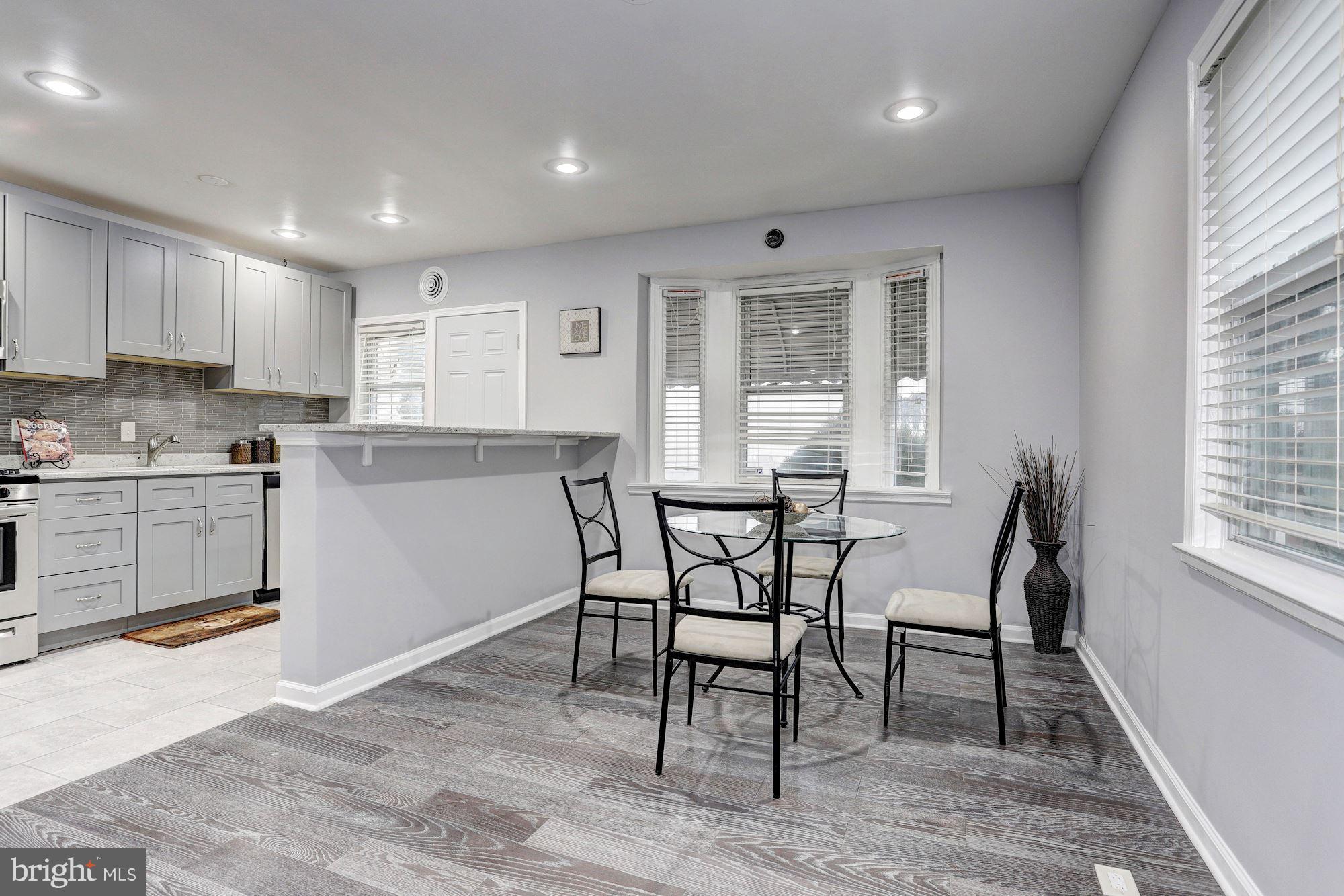 4510 Marble Hall Road Baltimore, MD 21239 - Photo 7 of 24 a kitchen with a table chairs wooden cabinets and stainless steel appliances