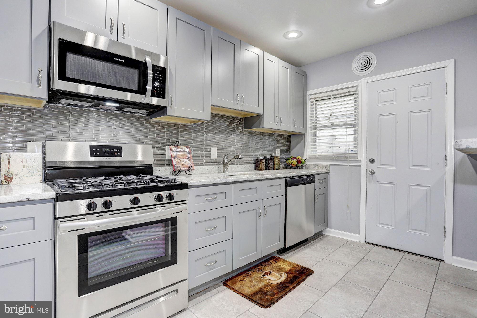 4510 Marble Hall Road Baltimore, MD 21239 - Photo 9 of 24 a kitchen with stainless steel appliances a stove a microwave and cabinets