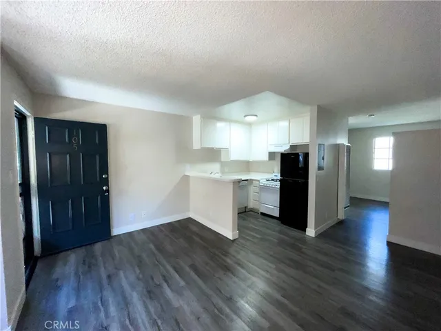 a view of kitchen with refrigerator cabinets and wooden floor