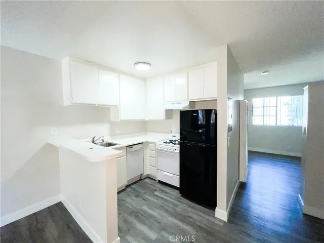 a kitchen with a refrigerator and a stove top oven