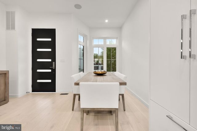 a kitchen with stainless steel appliances kitchen island a table and chairs