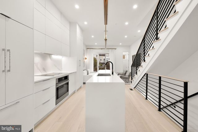 a large white kitchen with a large window