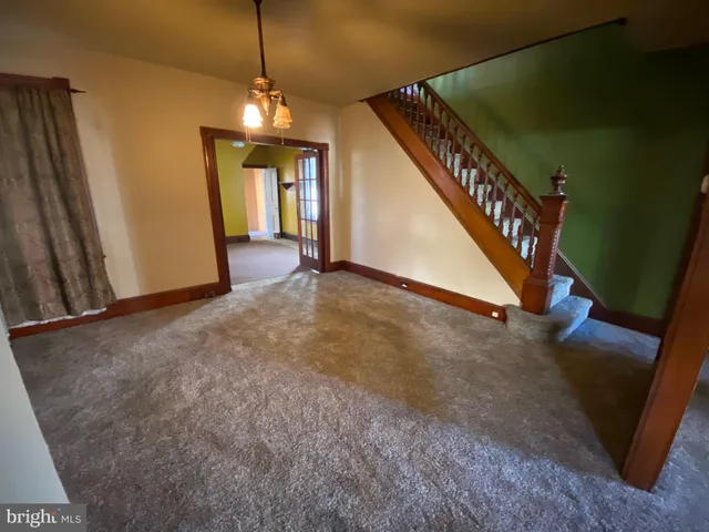 a view of a livingroom with wooden floor and stairs
