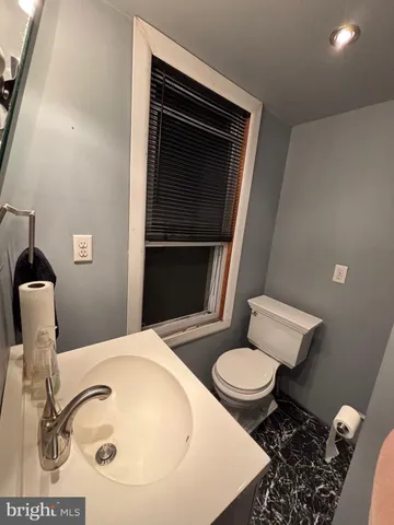 a bathroom with a sink toilet and mirror