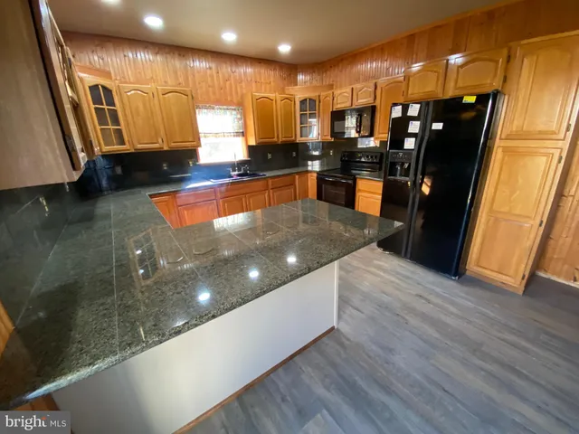 a large kitchen with stainless steel appliances a large counter top