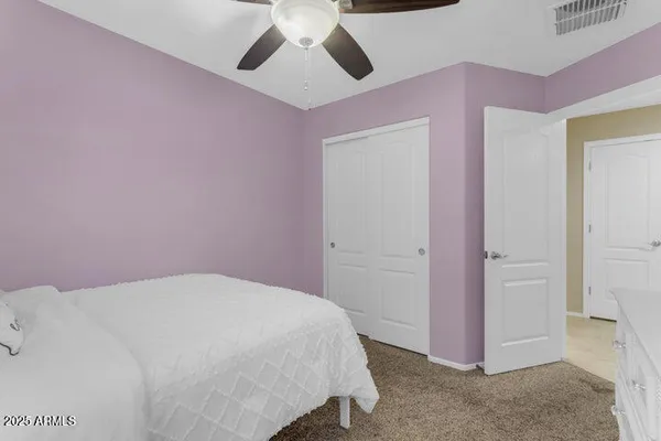 a bedroom with a bed and a chandelier fan