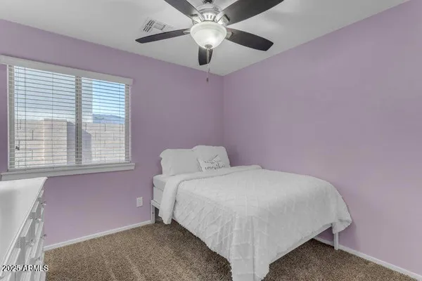 a bedroom with a bed and a chandelier fan