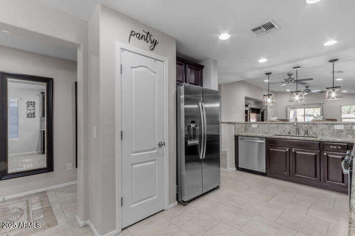 2220 East Stacey Road Gilbert, AZ 85298 - Photo 3 of 54 a kitchen with stainless steel appliances granite countertop a refrigerator a sink a stove with wooden cabinets