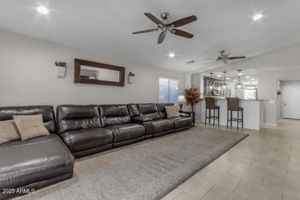 a living room with furniture and a ceiling fan