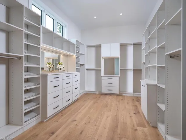 a bedroom with a bed lamp and a large window