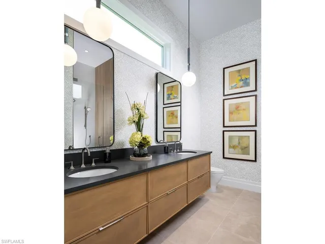 a bedroom with a large bed and a chandelier next to a window