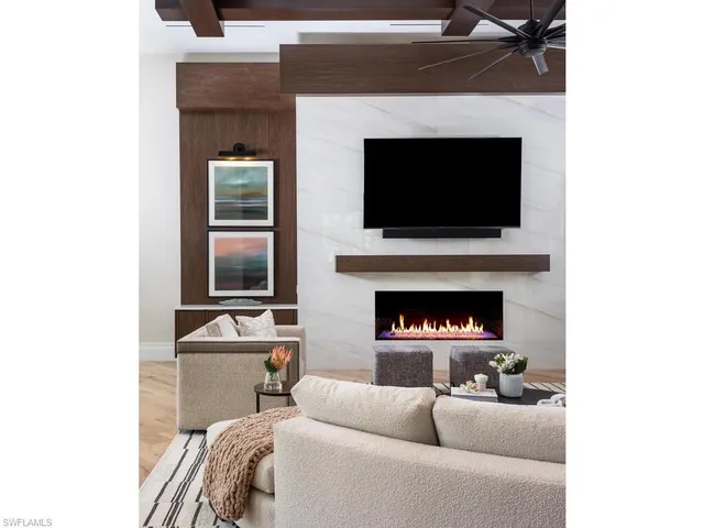 a living room with furniture a flat screen tv and a fireplace