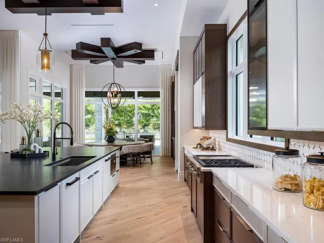 a kitchen with kitchen island granite countertop a sink stove and cabinets