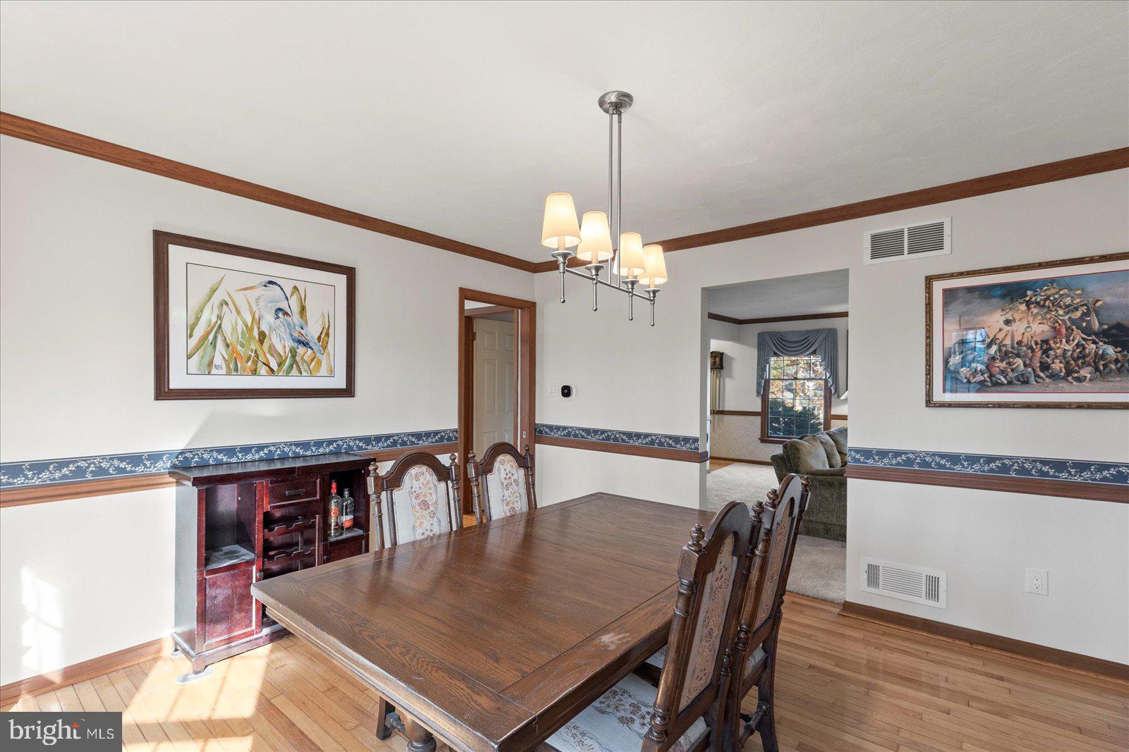 437 Valley View Drive Hanover, PA 17331 - Photo 13 of 40 a dining room with wooden floor a chandelier a wooden table and chairs