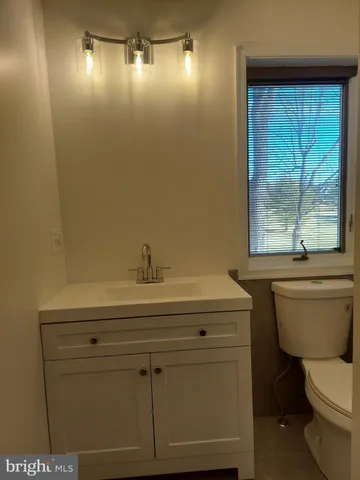 a bathroom with a sink a toilet and mirror