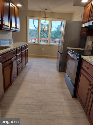 a kitchen with stainless steel appliances granite countertop a sink stove and cabinets