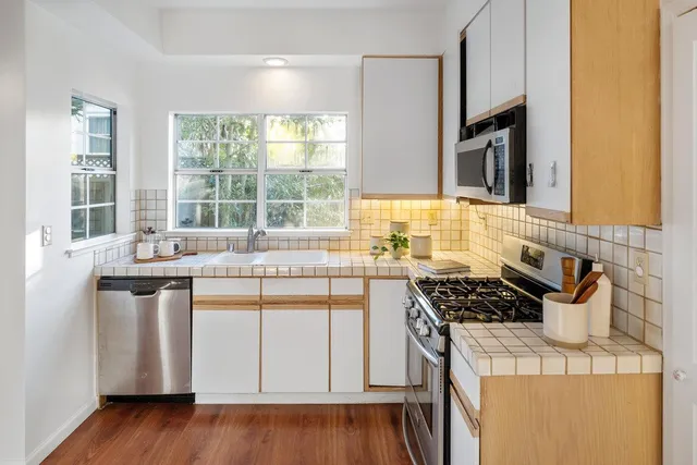 a kitchen with stainless steel appliances a stove a sink and wooden cabinets