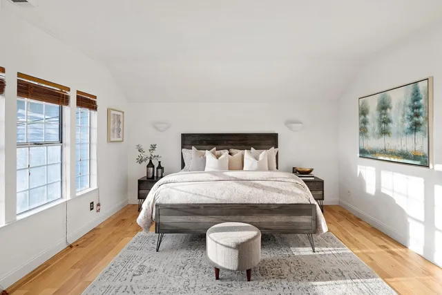 a bedroom with a bed and wooden floor