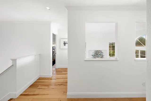 a view of a hallway with wooden floor and entryway