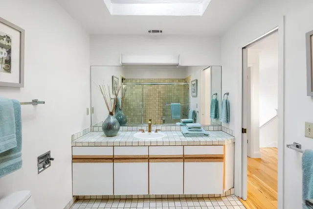 a bathroom with a granite countertop sink and a mirror