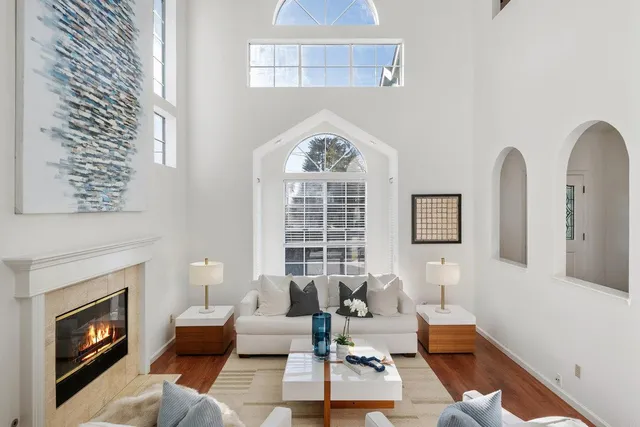 a living room with furniture a fireplace and a large window