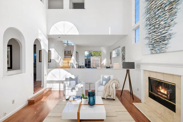 a living room with furniture a fireplace and a chandelier