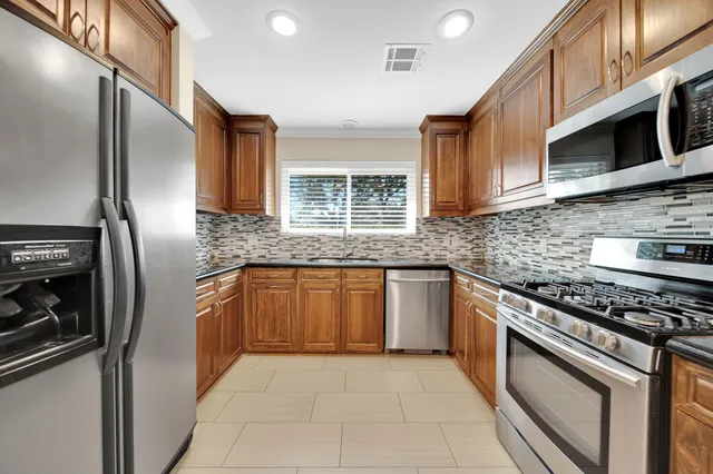 a kitchen with stainless steel appliances granite countertop a stove sink and microwave