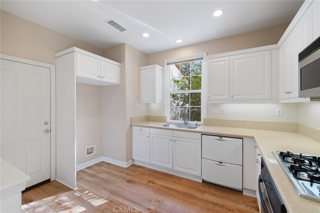 119 White Flower Irvine, CA 92603 - Photo 12 of 38 a kitchen with granite countertop a stove and a sink