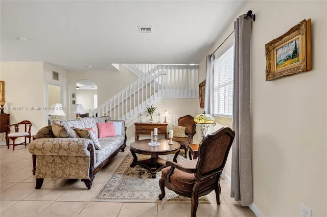 a living room with furniture and a potted plant