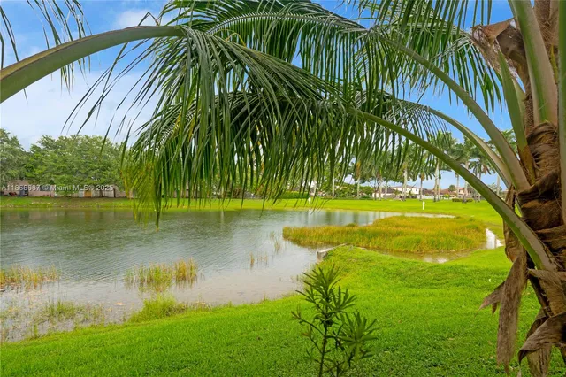 an aerial view of a residential houses with outdoor space and lake view