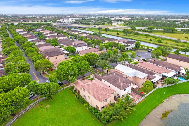 an aerial view of a city with lots of residential buildings ocean and mountain view in back